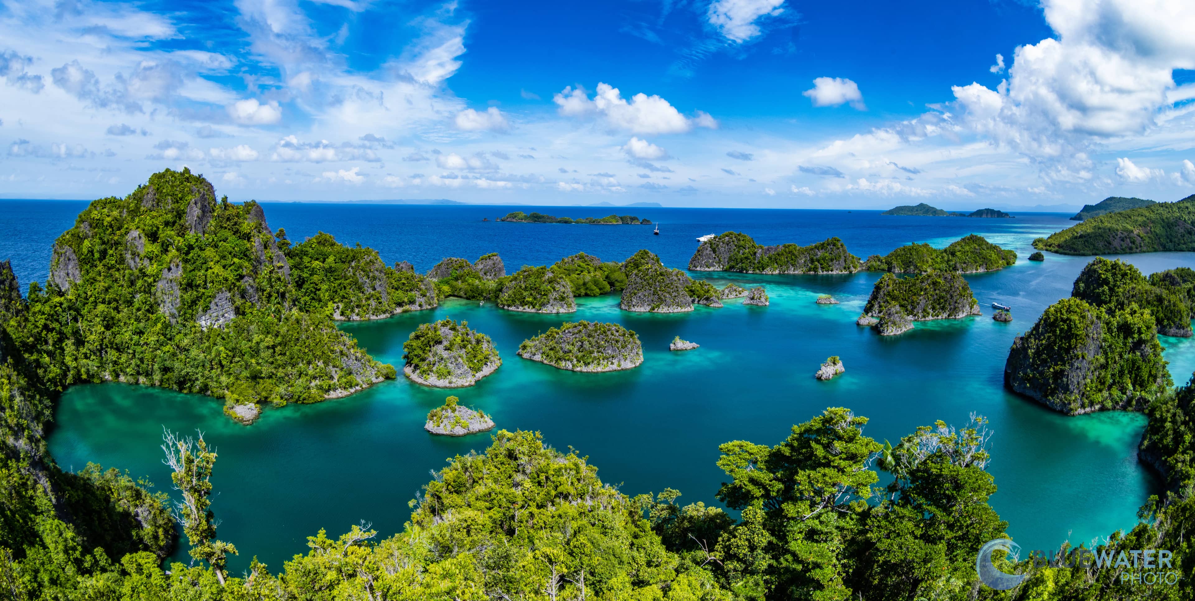 a breathtaking tropical seascape featuring numerous small, lush green islands scattered across vibrant turquoise and deep blue waters. a breathtaking tropical seascape featuring numerous small, lush green islands scattered across vibrant turquoise and deep blue waters.