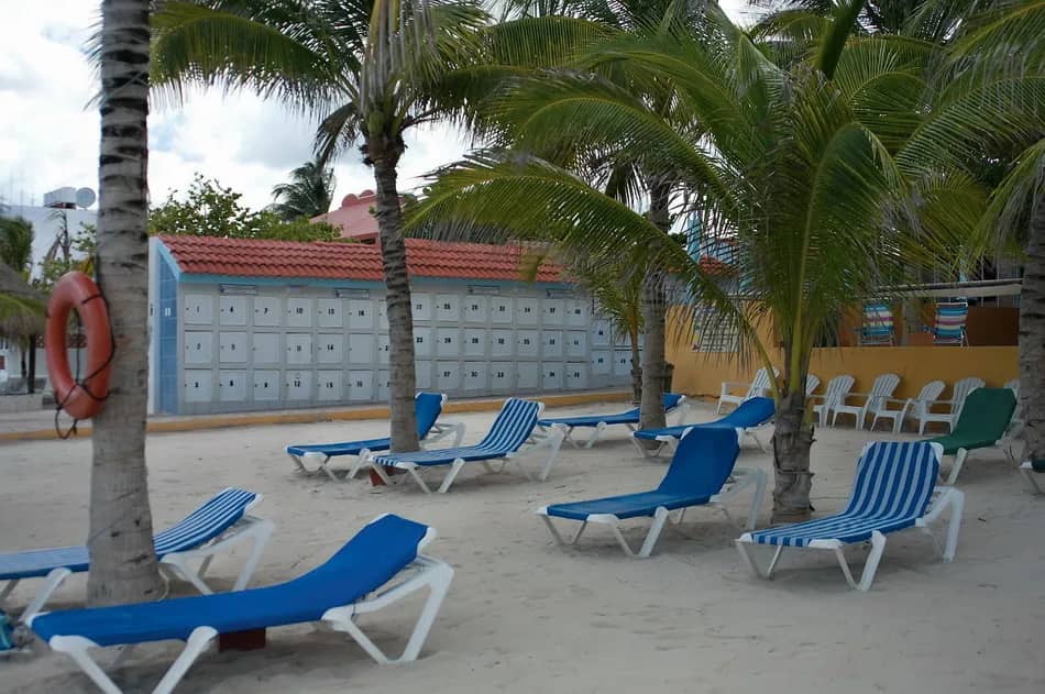 Lounge chairs sit unattended on a beach. Lounge chairs sit unattended on a beach.