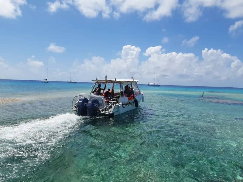 A dive boat pulls away from Motu Aito Paradise A dive boat pulls away from Motu Aito Paradise