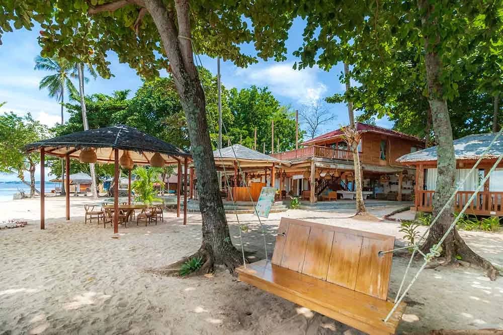 Beachfront of the resort with hammocks and couches Beachfront of the resort with hammocks and couches